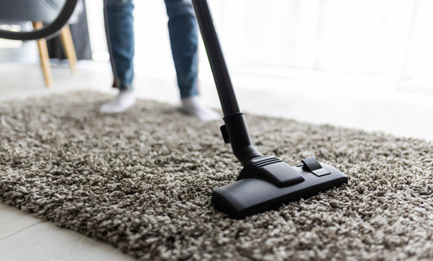 a man vacuuming the carpet 